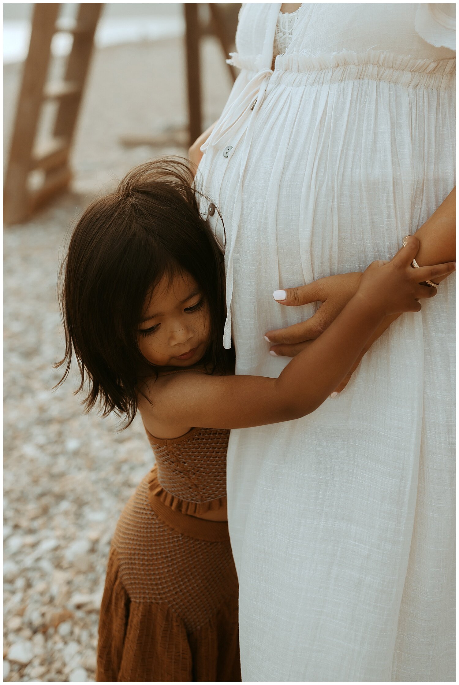 daughter hugging moms pregnant belly